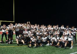  utica high school football team poses for picture as a team holding their hands like a 'U'