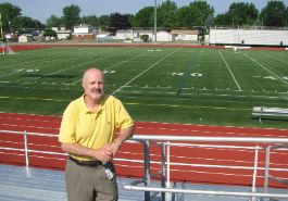 Robin Dilday standing on bleachers with football field in the background